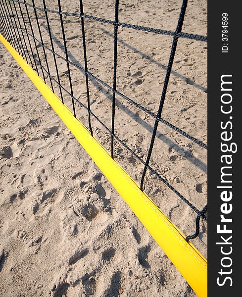 Yellow volleyball net shot from above, visible sand