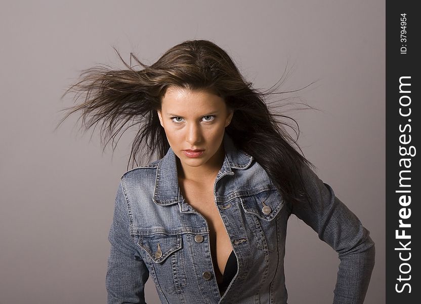 A fresh brunette fashion model in denim jacket unbuttoned. A fresh brunette fashion model in denim jacket unbuttoned