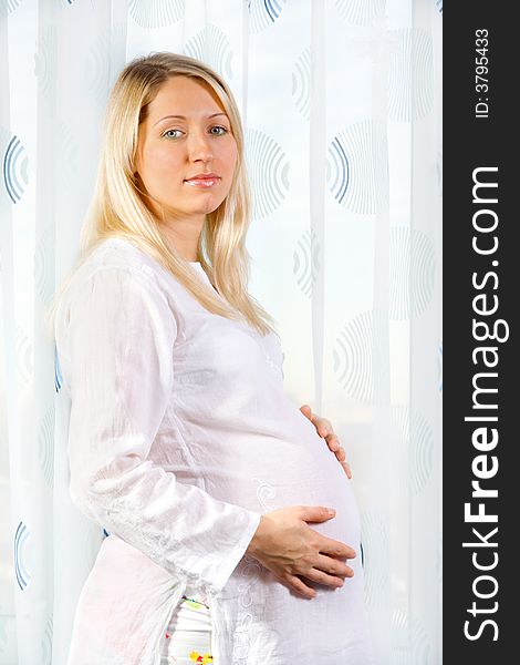 Pregnant woman standing and looking at camera
