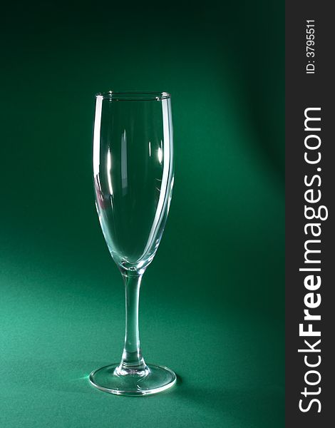 Single champagne glass on green background