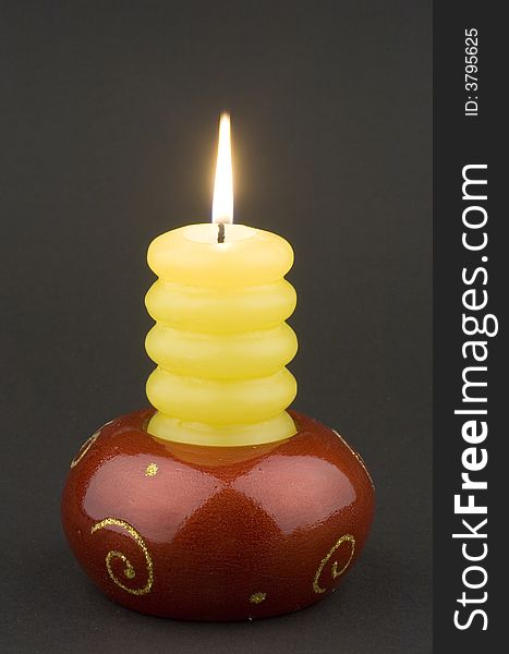 Yellow candle on black background
