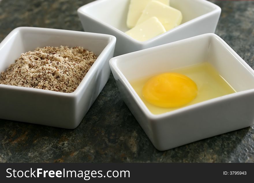 Raw eggs, butter and flour on a granite countertop. Raw eggs, butter and flour on a granite countertop