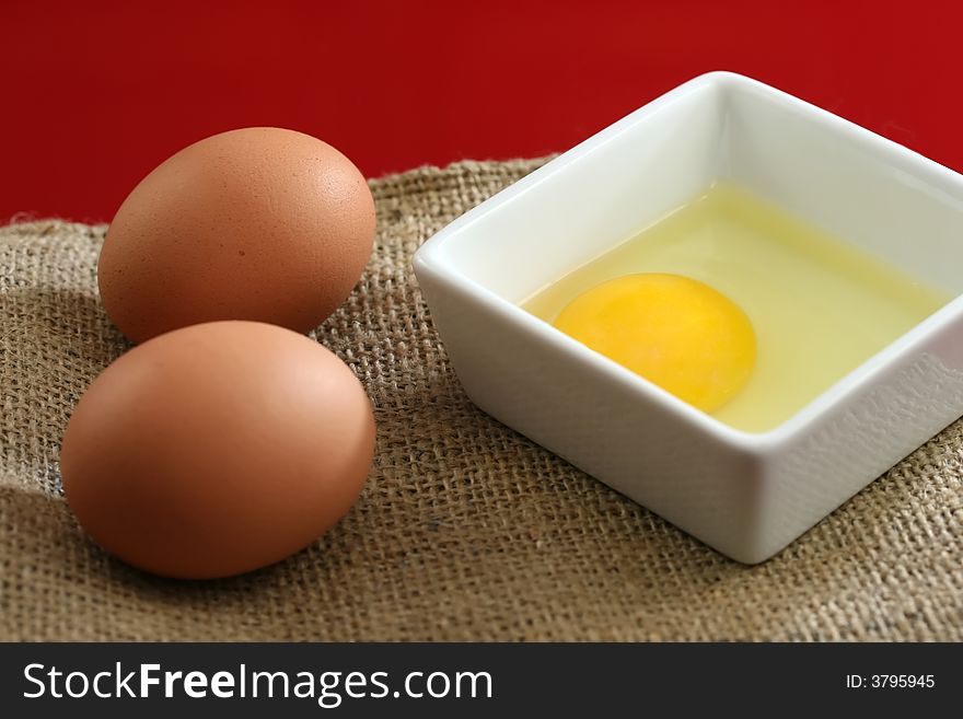 Healthy raw eggs on a red background