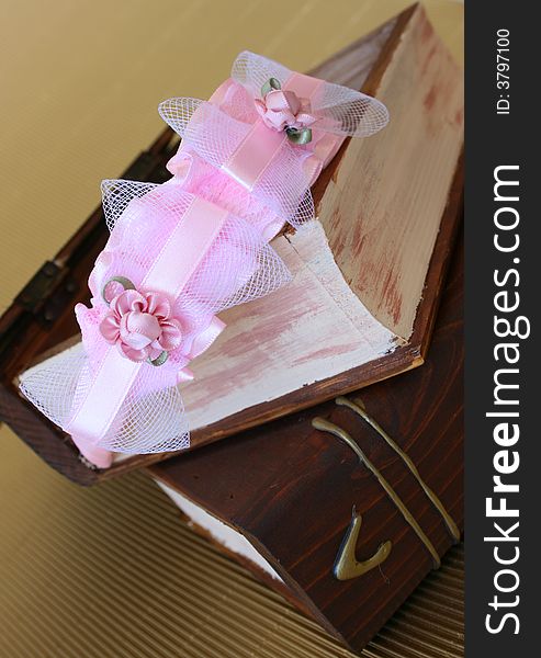 Pink Hair Accessories on a woonden jewellery box, on a golden background