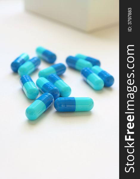 Scattered blue capsules on white background. Scattered blue capsules on white background