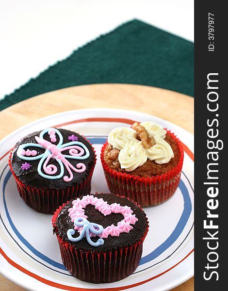 Fancy carrot and chocolate cupcakes with icing design on top