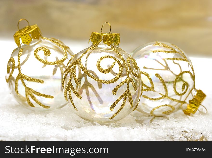 Golden Christmas balls on snow background