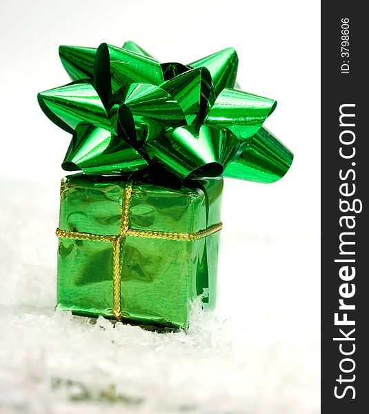 Green gift box on white snow
