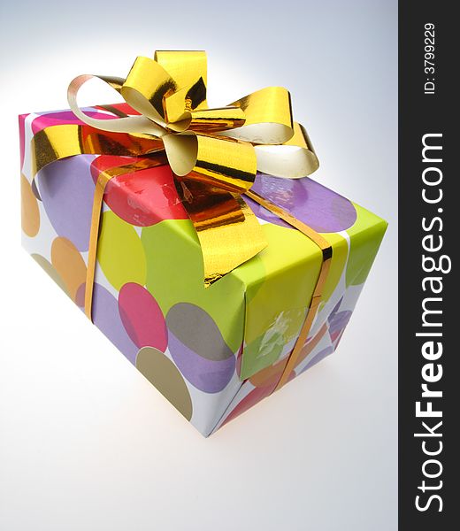 Gift in  box packed into  bright color paper  on white background