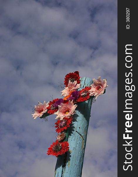 Colourful flowers mounted in the shape of a cross against a blue sky. Photographed from a church in Cozumel, Mexico. Colourful flowers mounted in the shape of a cross against a blue sky. Photographed from a church in Cozumel, Mexico.