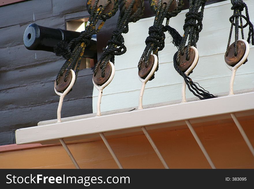 A close up of the side of a sailing ship, ropes and canon. A close up of the side of a sailing ship, ropes and canon.