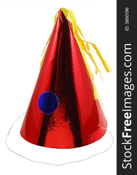 A shiny red party hat with blue circle and yellow tassle. A shiny red party hat with blue circle and yellow tassle