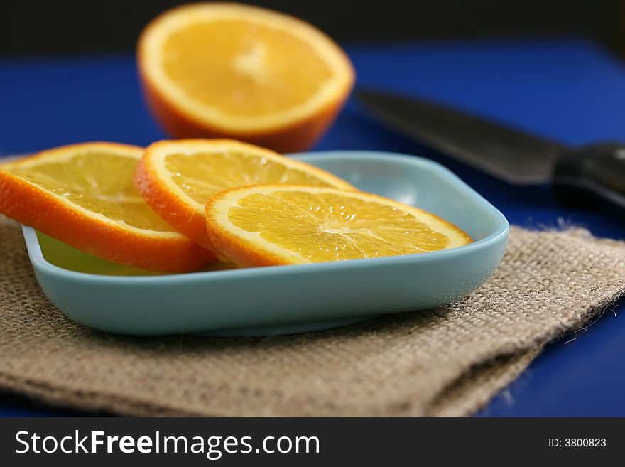 Orange slices on a plate on a blue table