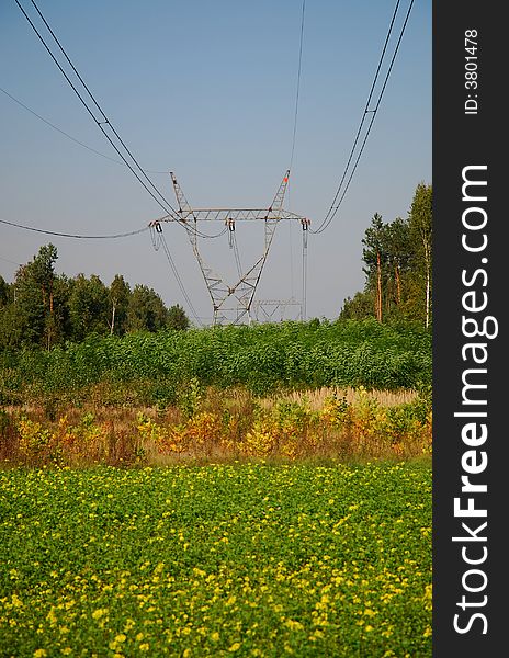 High voltage tower over cloudy blue sky