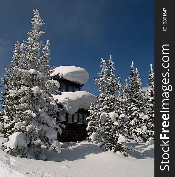 An old fire lookout sits under a blanket of snow. An old fire lookout sits under a blanket of snow