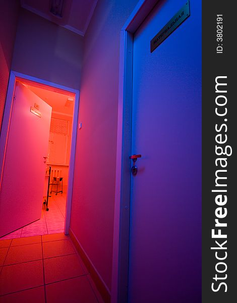 Mysterious corridor with blue light and opened door to medical cabinet with red light. Mysterious corridor with blue light and opened door to medical cabinet with red light.