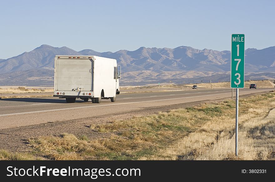 Truck driving towards mountains in Utah. Truck driving towards mountains in Utah.