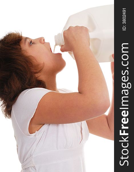 Close-up of a preteen girl guzzling milk straight from a gallon jug. Close-up of a preteen girl guzzling milk straight from a gallon jug.