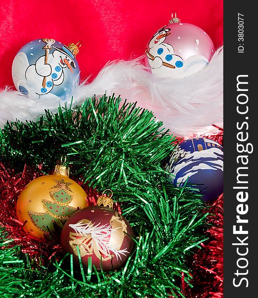 Several painted glass ball christmas decorations among red and green tinsel