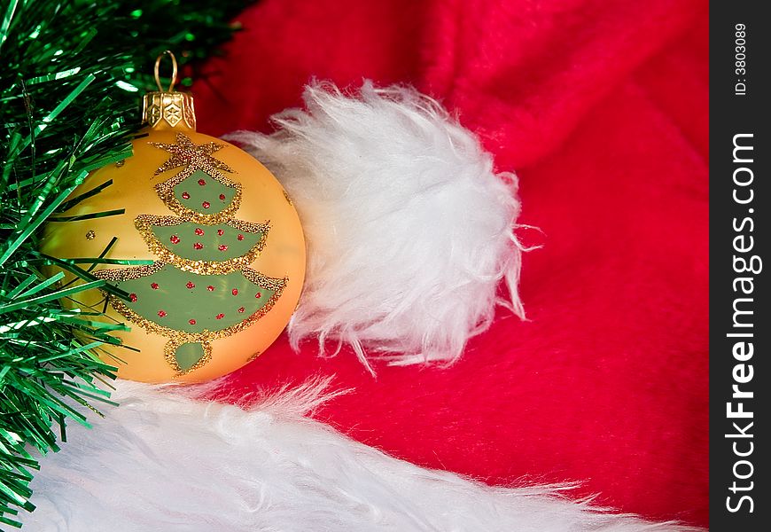 Christmas tree on a glass ball sitting on a santa hat with tinsel trimming