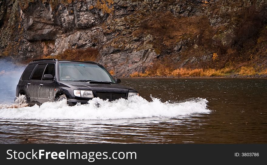 Car Subaru Forester overcomes the taiga river. Car Subaru Forester overcomes the taiga river