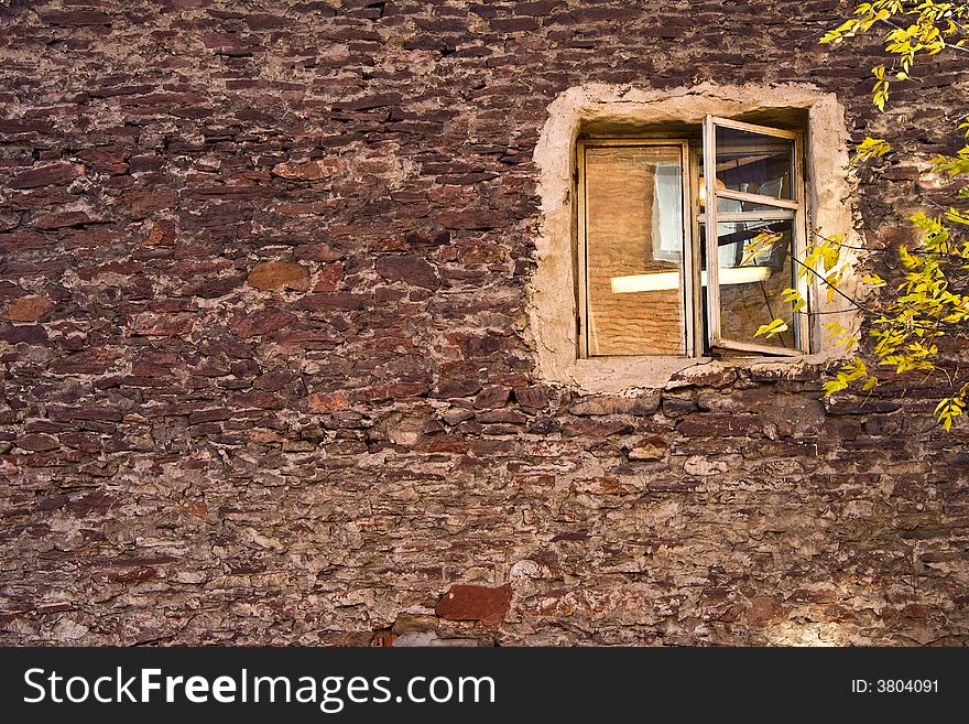 Autumn window on an impressive brick wall