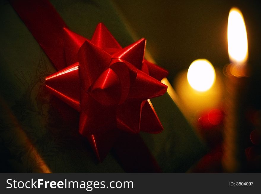 Ornaments - ribbon, present, candles on a dark background. Ornaments - ribbon, present, candles on a dark background