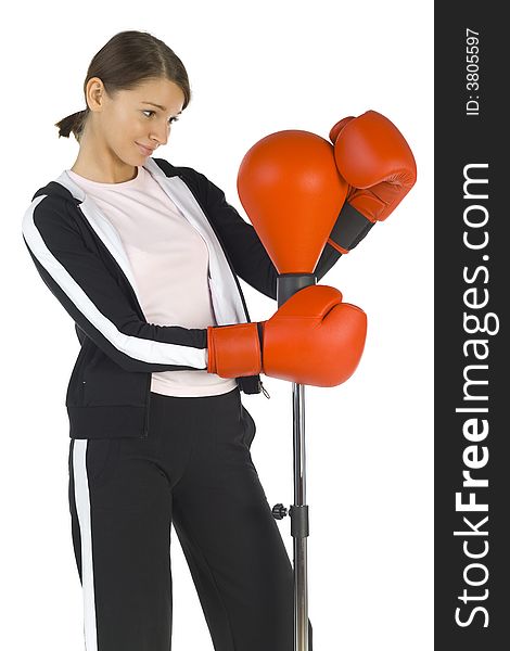 Young beauty with boxing gloves. Hugging punch bag. Smiling and looking at bag. White background, side view. Young beauty with boxing gloves. Hugging punch bag. Smiling and looking at bag. White background, side view