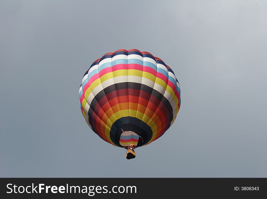 Looking up at a multi colored hot air balloon