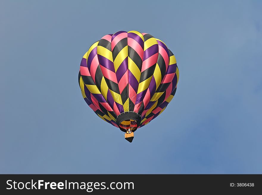 Multi colored hot air balloon from the ground below