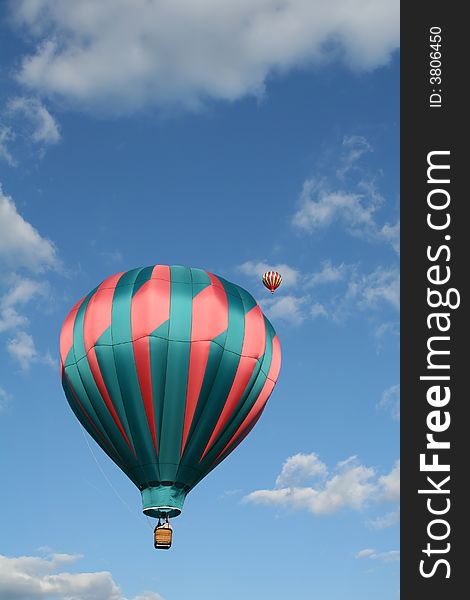 Two hot air balloons with a cloudy sky