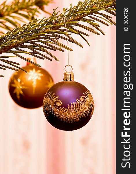 A purple christmas decoration hanging from a fir tree. A purple christmas decoration hanging from a fir tree