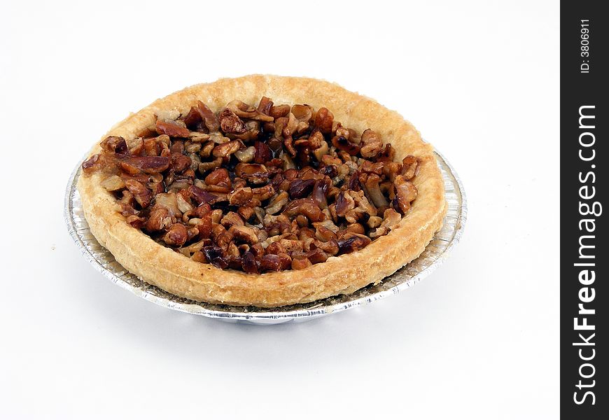 A miniature pecan pie in a tin pie pan. A miniature pecan pie in a tin pie pan.