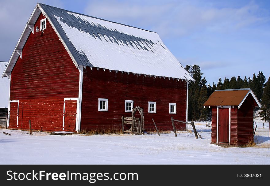 Red barn and matching outhouse in early winter in central Idaho. Red barn and matching outhouse in early winter in central Idaho