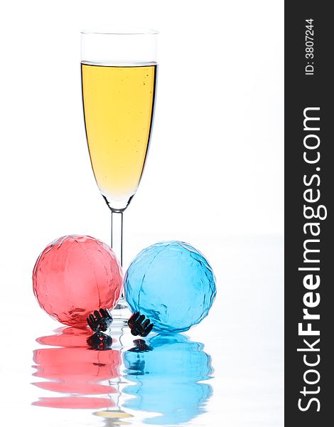Glass with champagne on a white background and a Christmas ornament. Glass with champagne on a white background and a Christmas ornament