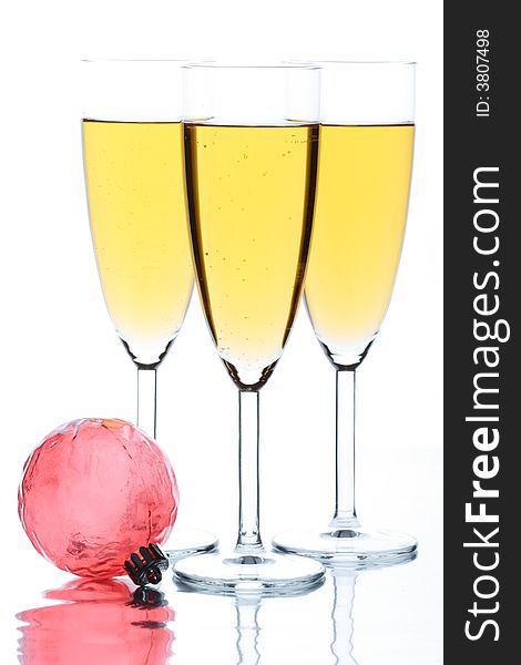 Three glasses with champagne on a white background and a Christmas ornament. Three glasses with champagne on a white background and a Christmas ornament