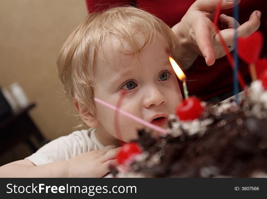 The boy llooks in wide-eyed the candles. The boy llooks in wide-eyed the candles