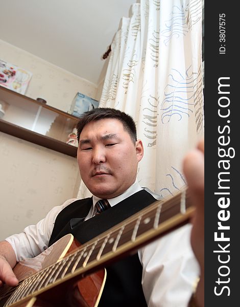 The man playing the guitar at home. The man playing the guitar at home