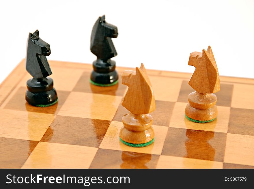 Two pairs of horses on chess board on white background isolated