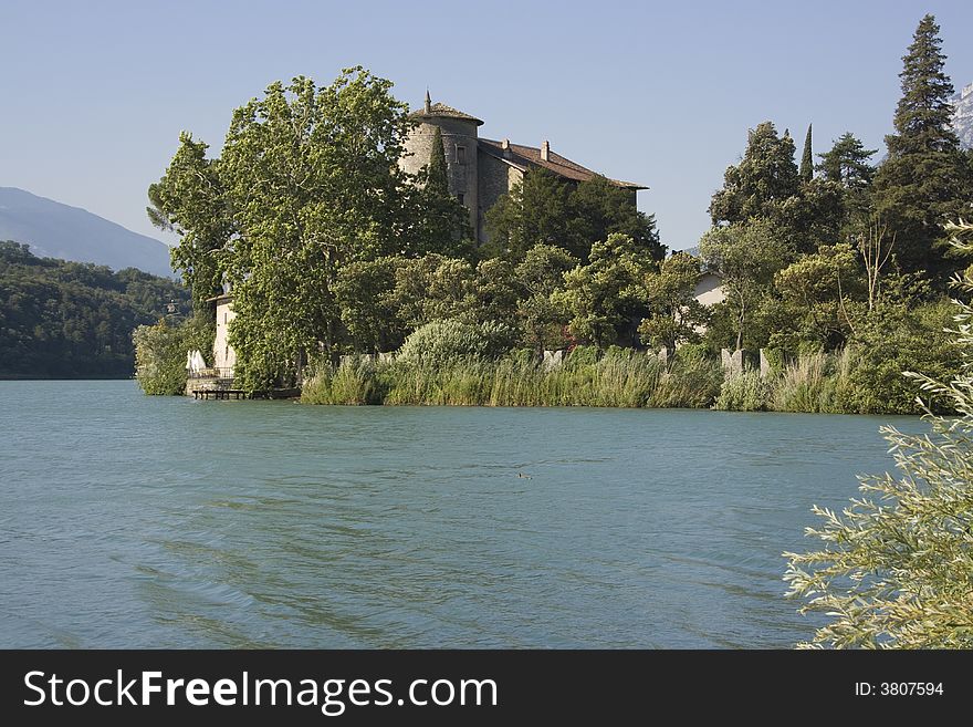 Old castle surrounded by lake. Toblino, Italy