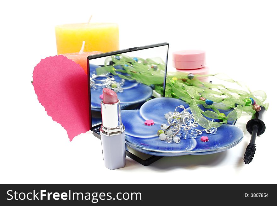 Jewelry and make up (lipstick, blush, eye care) and candles isolated over white