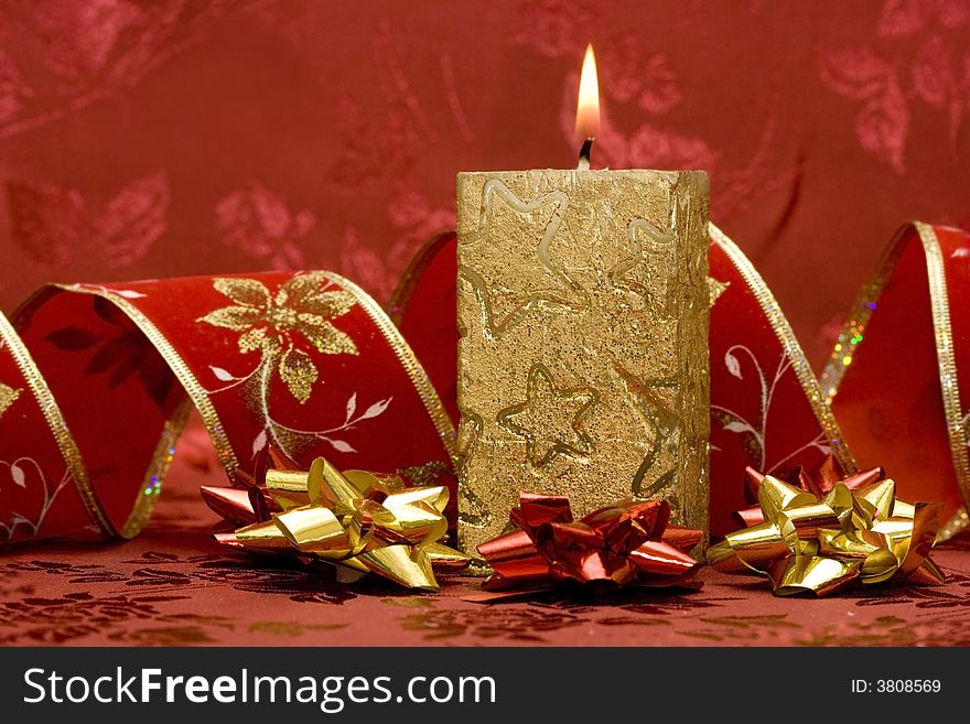 Golden candle on red background