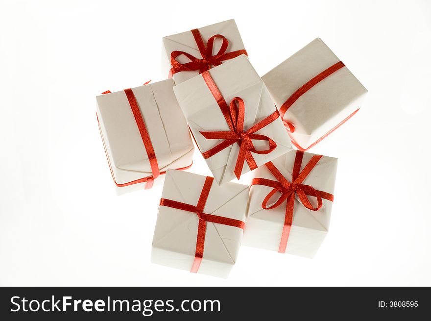 Small white boxes with gifts on a white background