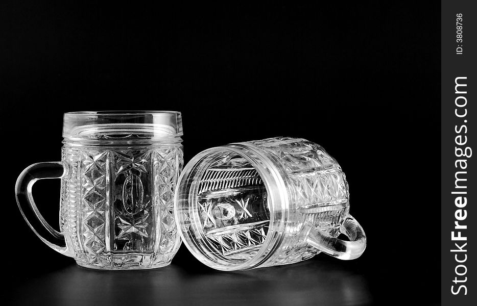 Two crystal glass with reflection isolated on a black background