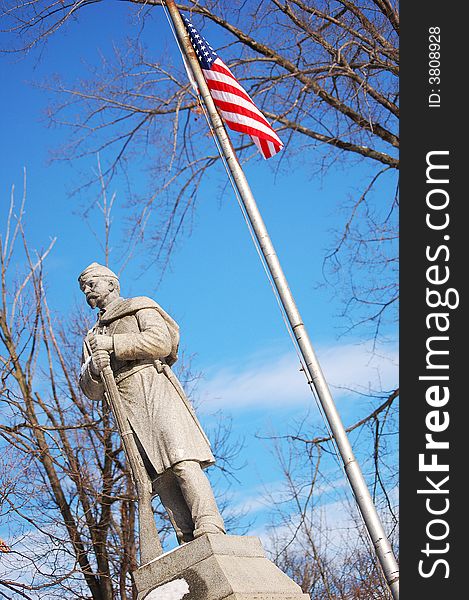 A civil war soldier statue with the American flag. A civil war soldier statue with the American flag