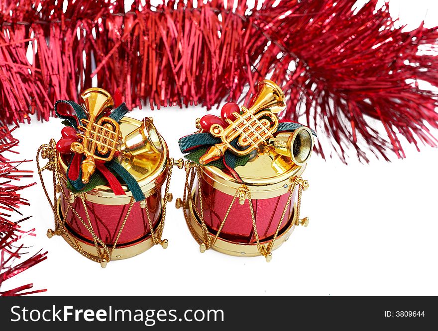 Two Christmas decorations - drums with bells and trumpet with red tinsel on white background. Two Christmas decorations - drums with bells and trumpet with red tinsel on white background