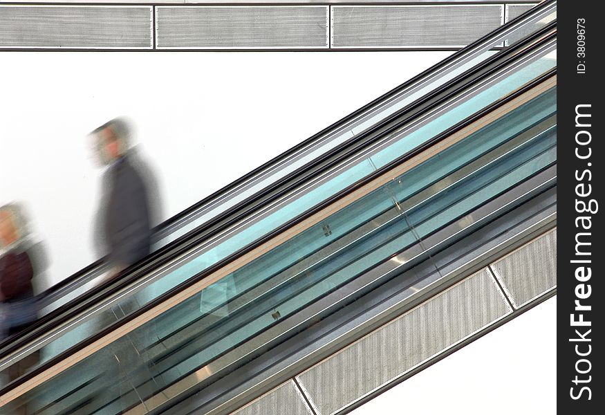 People walking on escalator (Blurred motion demonstrates the speed). People walking on escalator (Blurred motion demonstrates the speed)