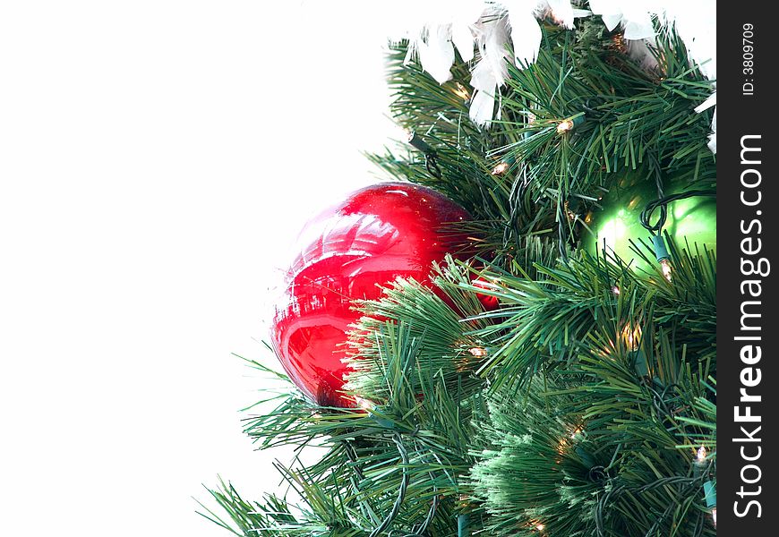 Beautiful christmas tree close-up with reflection of stores inside a shopping mall showing on the big red ornament (Isolated on white background)