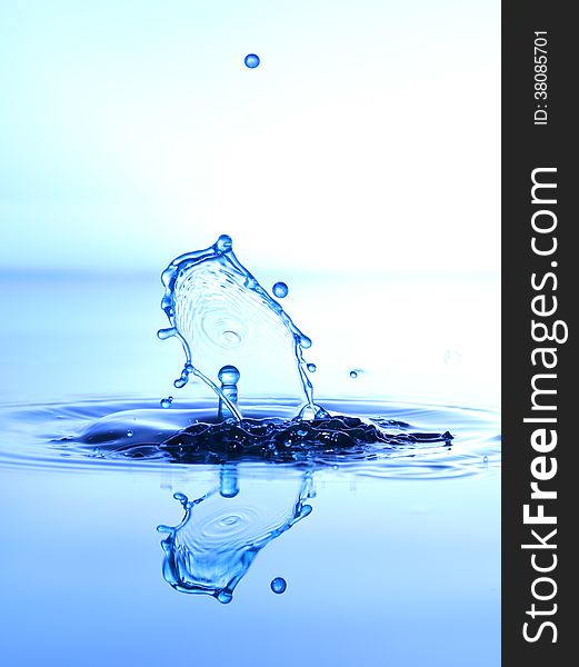 Splashing water drops on color background.Color waterdrops collide each other.