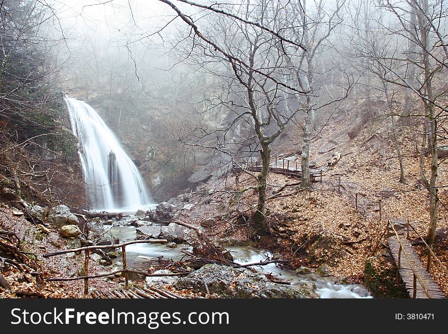 Waterfall In Foggy Forest